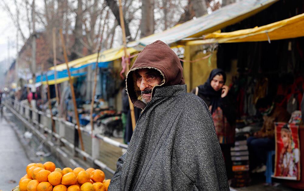 A Kashmiri street vendor, covered in woolen clothes, waits for customers in Srinagar. Cold wave continued to sweep most parts of northern India with widespread snowfall in the hilly areas, according to news reports.