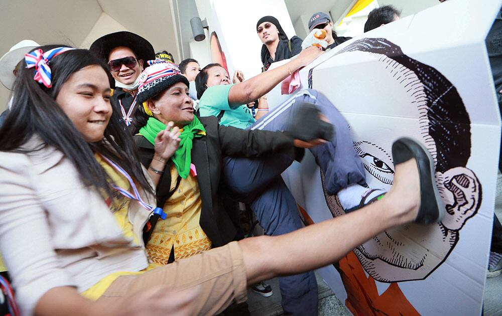 Thai anti-government protesters kick and hit at the drawing of Tharit Pengdit, chief of the Department of Special Investigation (DSI), after storming into his office during a rally in Bangkok.