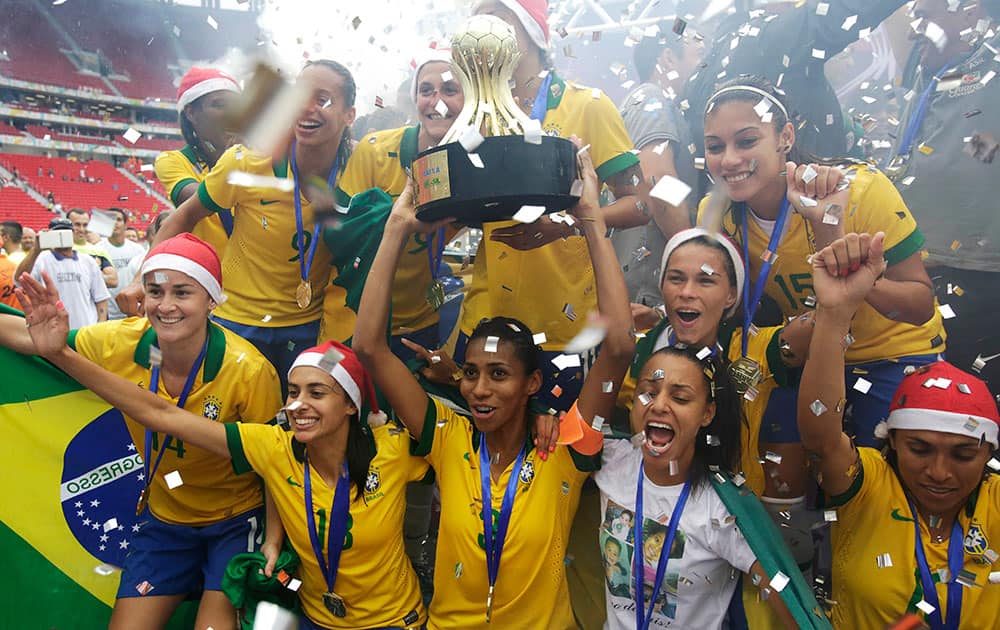 Brazil captain Bruna Beatriz, center, raises the championship cup while joined by teammates after their 5-0 victory over Chile during the final soccer match at the International Women`s Football Tournament in Brasilia, Brazil.