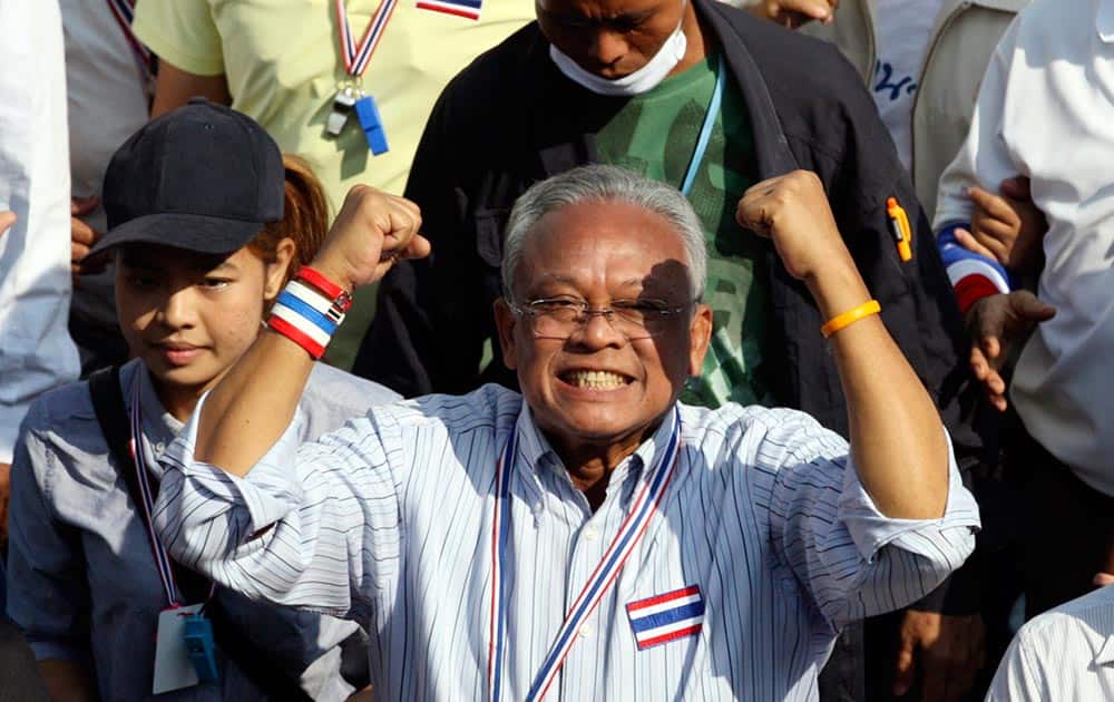 Thai anti-government protest leader Suthep Thaugsuban holds clenched fists during a march with his supporters in Bangkok, Thailand.