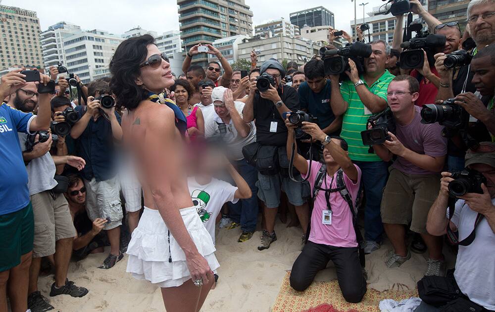 A woman poses for photos during a protest against a topless ban on the Ipanema beach, in Rio de Janeiro, Brazil.