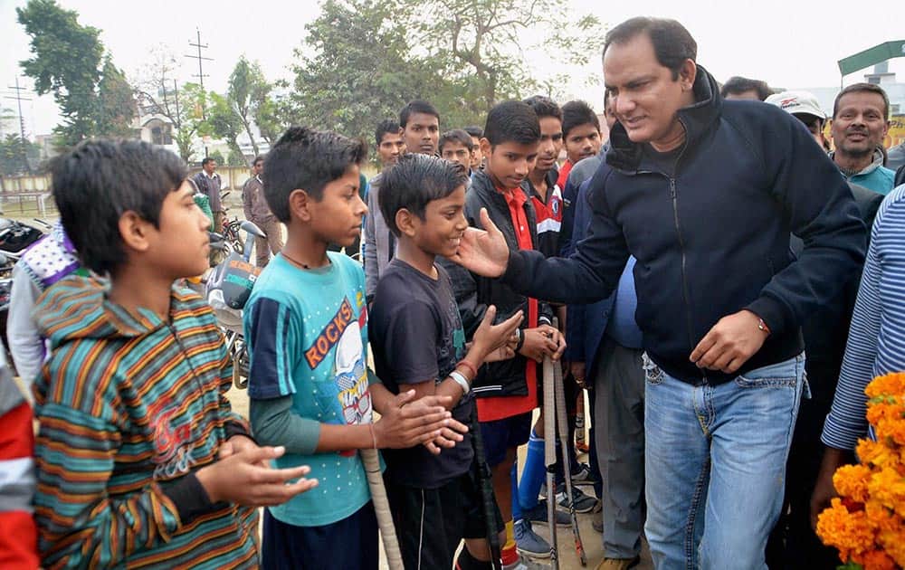 Congress MP Mohammed Azharuddin interacts with young hockey players during inauguration of flood lights at a stadium in Moradabad.