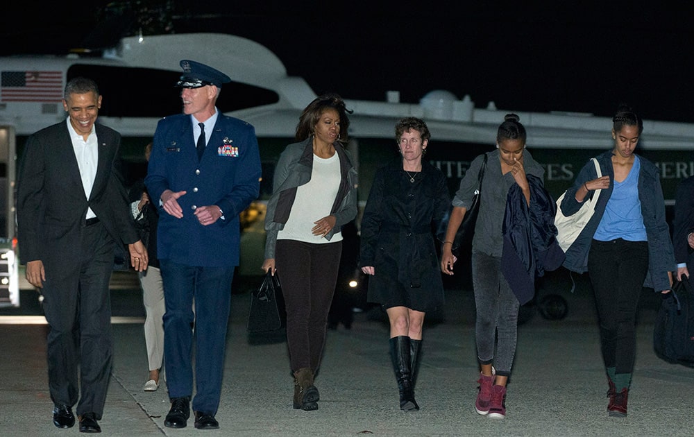 President Barack Obama and first lady Michelle Obama and their daughters Sasha and Malia, right, walk from Marine One to board Air Force One.