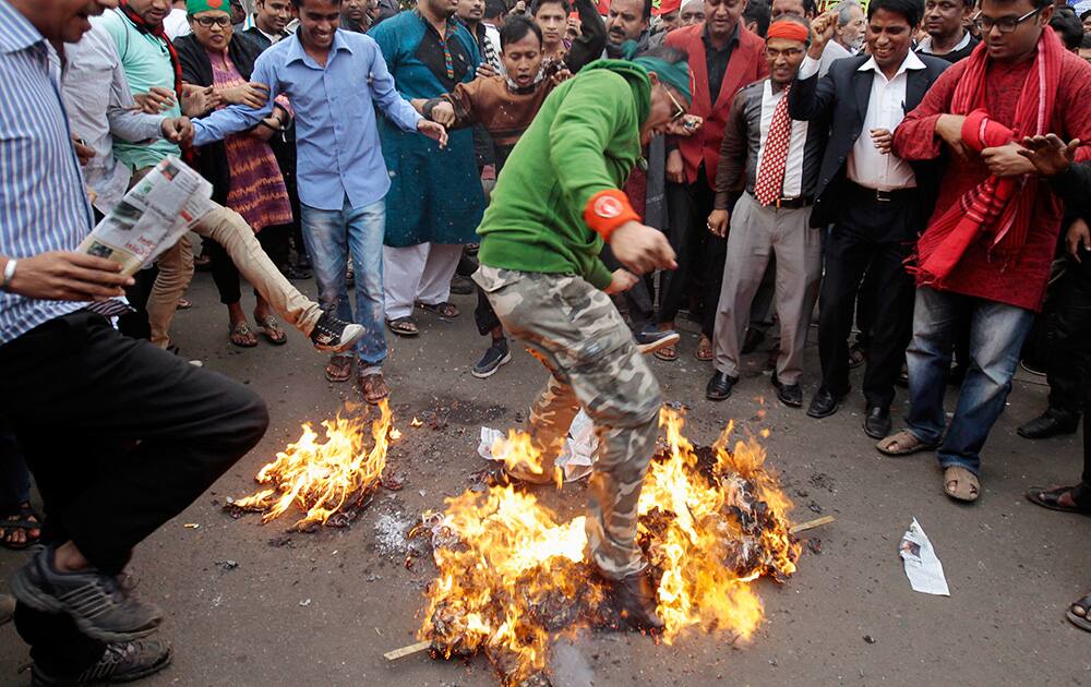 Bangladeshi activists burn an effigy of Pakistan Home Minister Chaudhry Nisar Ali Khan and representation of Pakistan’s flag to protest against his statement after the execution of Jamaat-e-Islami leader Abdul Quader Mollah in Dhaka, Bangladesh.