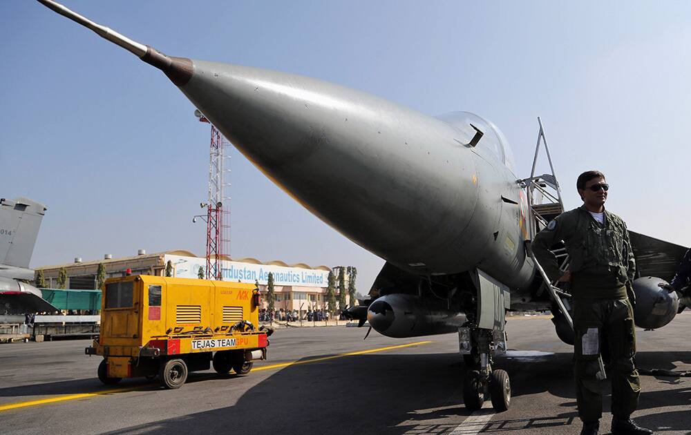 A pilot stands next to India`s indigenously designed and developed combat aircraft Tejas at Hindustan Aeronautics Limited airport in Bangalore.