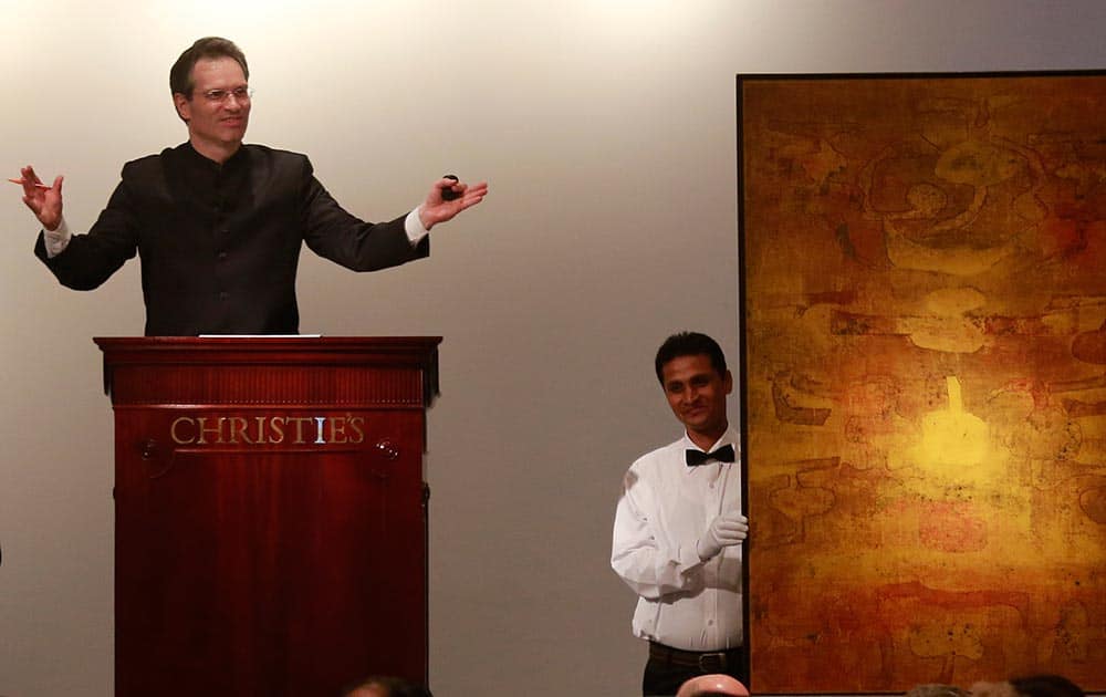 Christie’s International Director, Asian Art, Hugo Weihe, left, acts as auctioneer for the painting of Indian artist Vasudeo S. Gaitonde during Christie`s first auction in India in Mumbai.