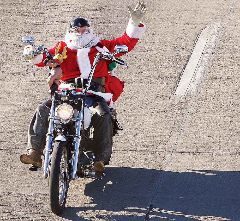 Herman Morgan of Florissant, Mo., takes advantage of the moderation in the weather, to dress up as Santa Claus and go for a ride through Alton, Ill., on his motorcycle.
