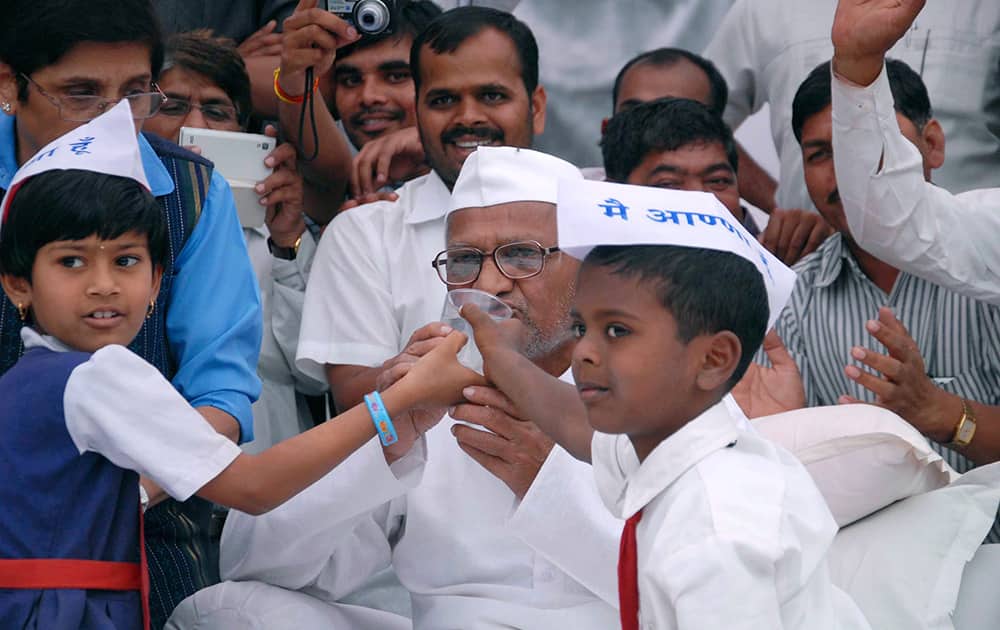 Anna Hazare drinks juice offered by children as he ends his nine-day hunger strike demanding an anti-graft legislation at Ralegan Siddhi, Maharashtra.