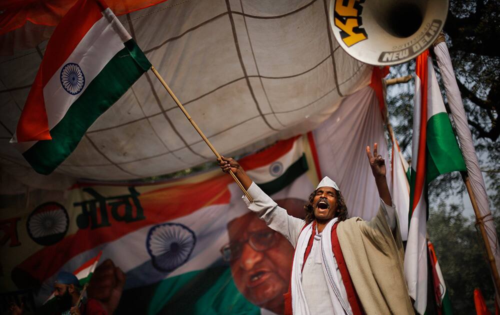 A supporter of social movement leader Anna Hazare waves the national flag as he celebrates the news of passing of a contentious anti-graft bill that empowers an independent ombudsman to investigate and prosecute cases of corruption by politicians and bureaucrats, in New Delhi.