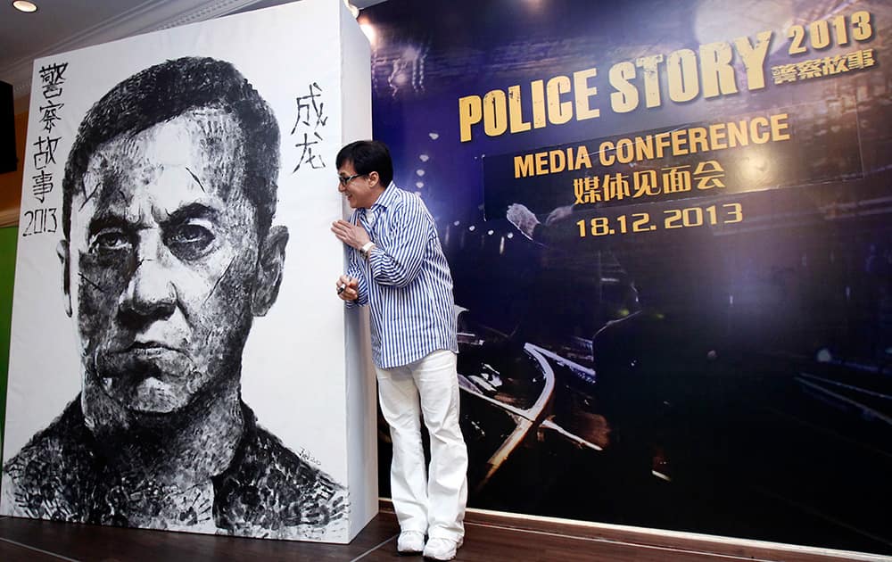 Hong Kong actor Jackie Chan looks at a portrait of himself during a press conference to promote his new film