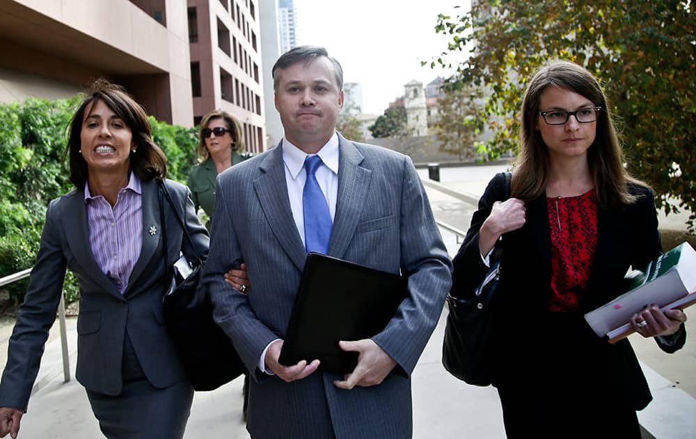 John Beliveau II, center, and his attorneys, Gretchen von Helms, left, and Jessica Carmichael arrive at the federal courthouse, in San Diego, where Beliveau is expected to plead guilty on bribery charges in connection with the over billing of the US Navy of millions of dollars.