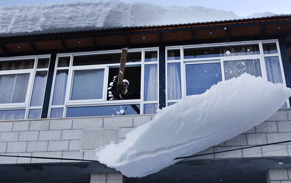 A Samaritan priest clears the snow on the roof of his house at Mount Gerzim near the West Bank town of Nablus.