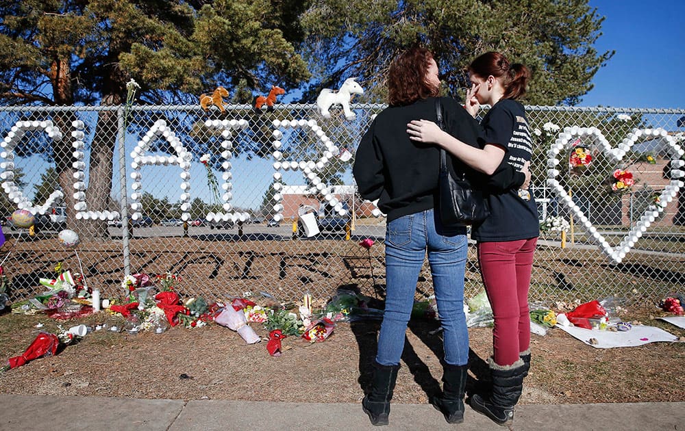 Arapahoe High School junior Emily Evans, right, and her mother Cristina hug while visiting a makeshift memorial bearing the name of wounded student Claire Davis, who was shot by a classmate during school three days earlier in an attack, in front of Arapahoe High School in Centennial, Colo.