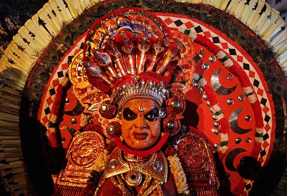 An Indian performer of Theyyam dances in a procession in honor of Lord Ayyappa in Ahmedabad, India.