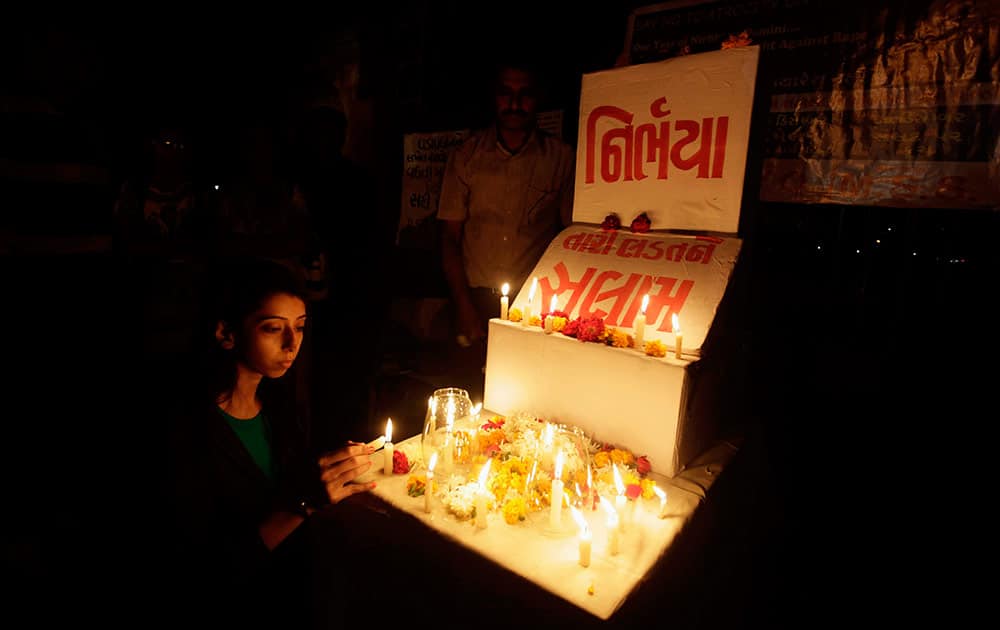 A young Indian girl places a candle in rememberance of last year’s gang rape and murder of a young woman in New Delhi, in Ahmadabad.