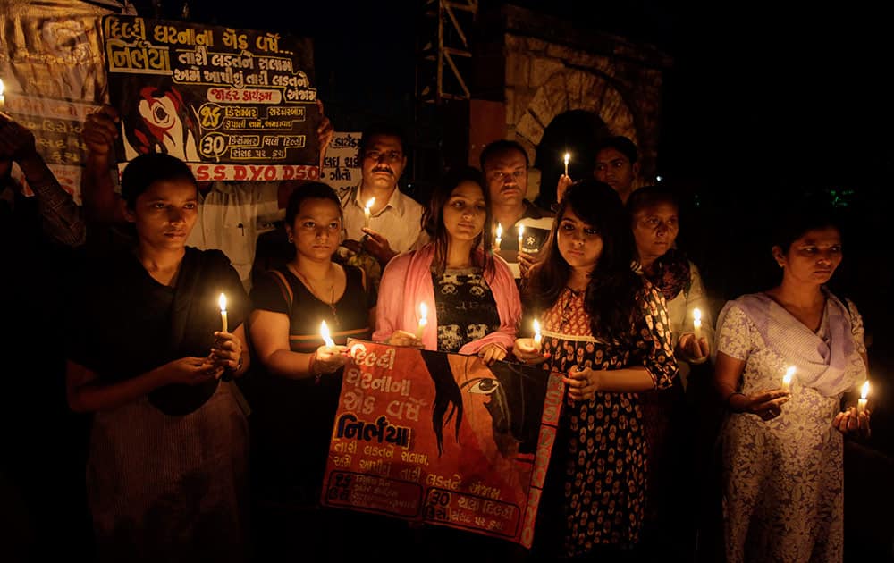 Indian people hold candles to pay tribute to last year’s gang rape and murder of a young woman in New Delhi, in Ahmadabad.