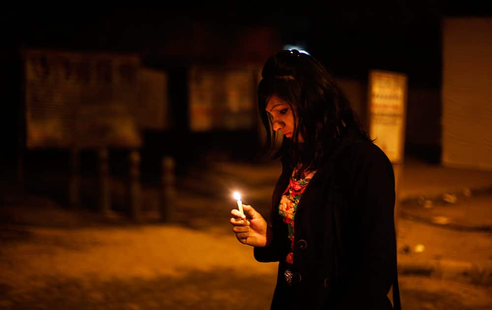 A young Indian woman holds a candle as she joins others in commemorating last year’s gang rape and murder of a young woman in New Delhi.