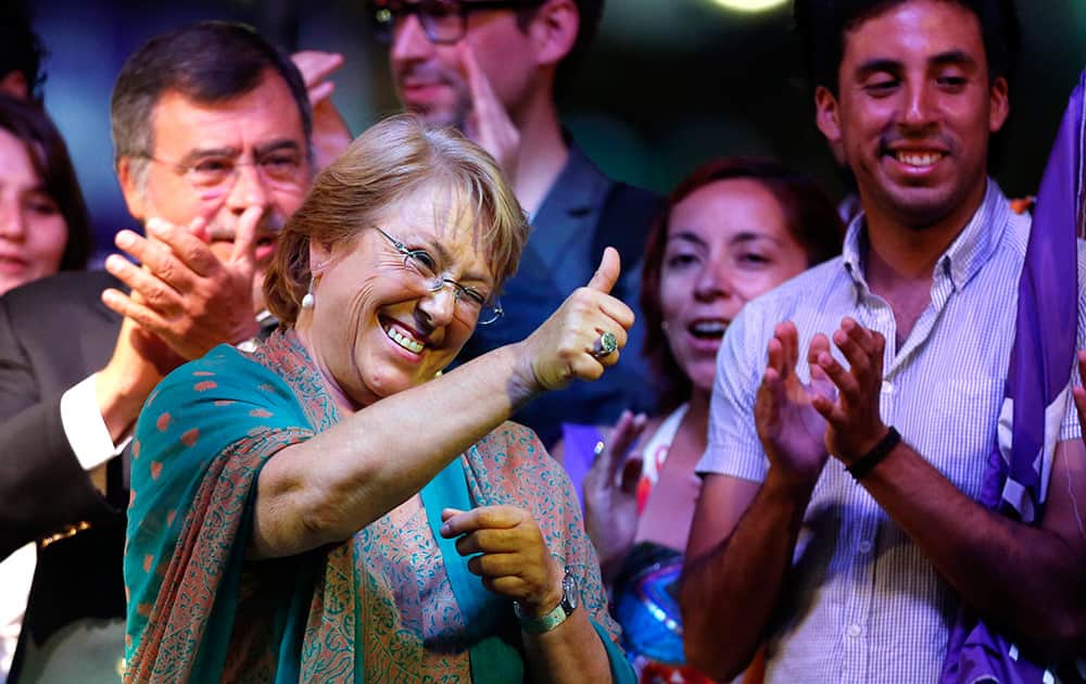 Presidential candidate and former President Michelle Bachelet gives the thumbs up sign during a victory rally in Santiago, Chile.
