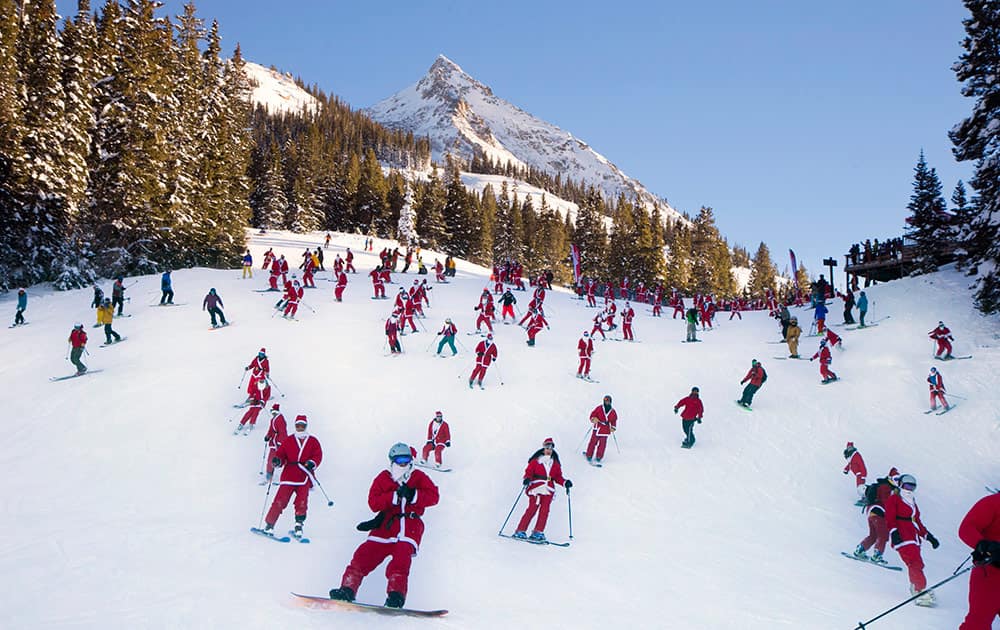 In this hand out image provided by Crested Butte Mountain Resort, shows participants dressed as Santas skiing from Uley`s Ice Bar on Crested Butte Mountain, Crested Butte, Colo., for the first `Santa Ski Crawl`.