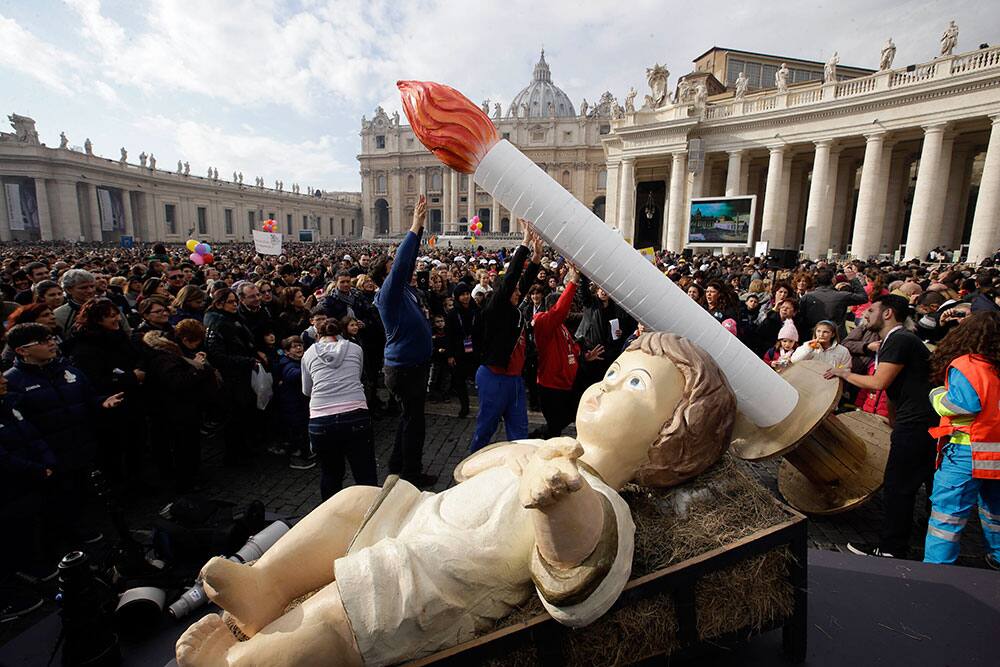 Faithful lift up a giant candle two days ahead of Pope Francis` 77th birthday, during the Pope`s traditional Sunday`s appearance in St. Peter`s Square at the Vatican.
