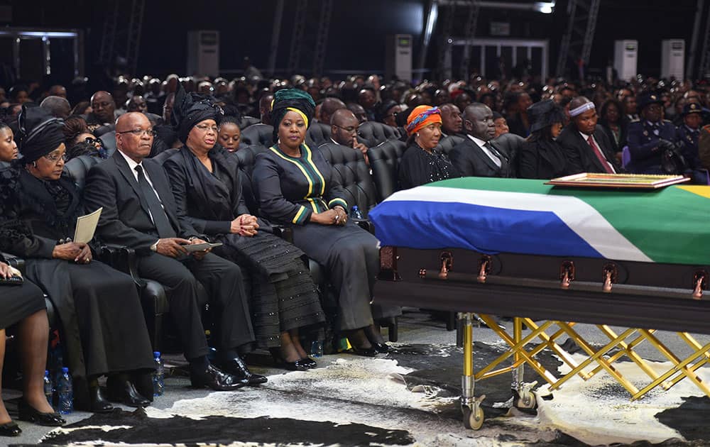South African President Jacob Zuma sits between Winnie Madikizela-Mandela, left, Nelson Mandela`s former wife, and Nelson Mandela’s widow Graca Machel during the funeral service for former South African President Nelson Mandela in Qunu, South Africa.