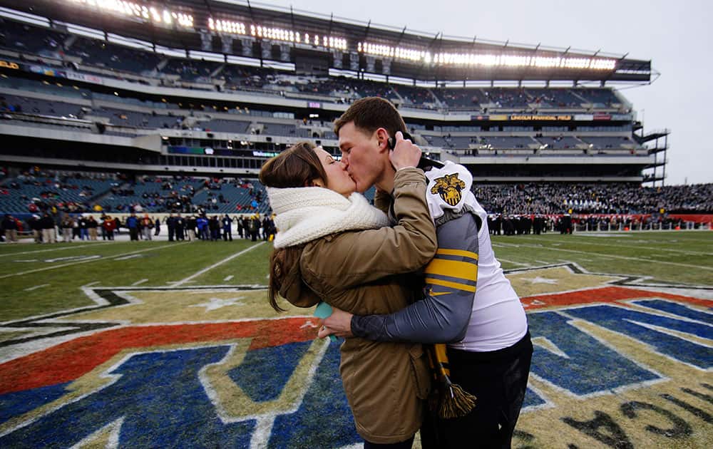 Colin Joy and Nicole Veroline kiss after Joy proposed to her on the field before the Army-Navy NCAA college football game, in Philadelphia. She said yes. The couple is from Long Island, N.Y.