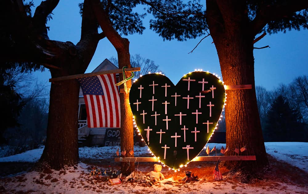 A makeshift memorial with crosses for the victims of the Sandy Hook massacre stands outside a home in Newtown, Conn. the one-year anniversary of the shootings.