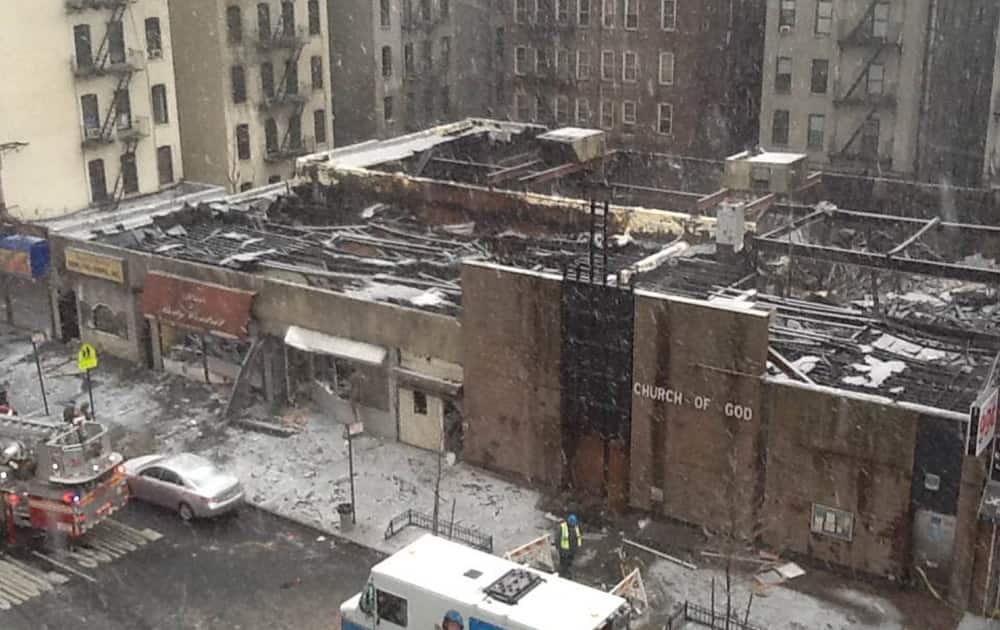 In this image taken from video, New York City firefighters and emergency workers look over the scene on Saturday, Dec. 14, 2013, after a 4-alarm fire engulfed multiple buildings Friday night, in the Harlem neighborhood of New York. Officials say more than 100 firefighters responded.