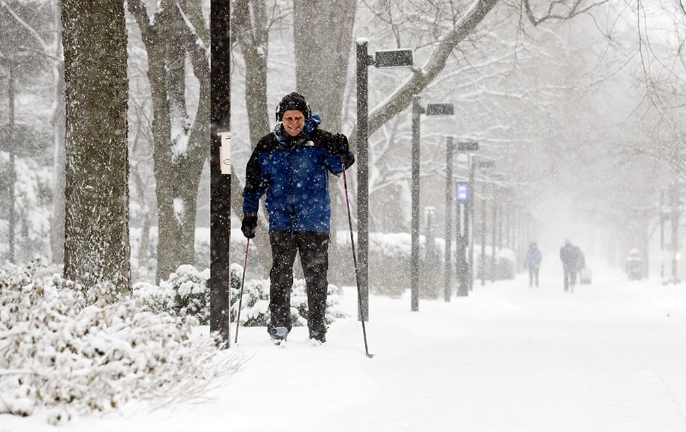 Marius Daugirdas skis on the sidewalk in Evanston, Ill. Snow continued to fall over the Chicago area into northwest Indiana.