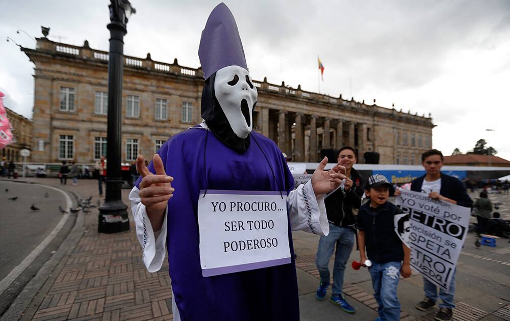 A supporters of Bogota`s Mayor Gustavo Petro dressed as a Catholic Bishop with a sign that reads in Spanish: