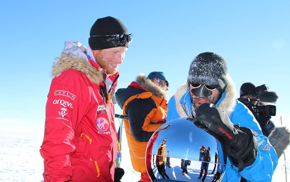 Britain`s Prince Harry and Ivan, touch the pole, as they and their fellow adventurers reach the South Pole, as part of their Walking With The Wounded charity trek.