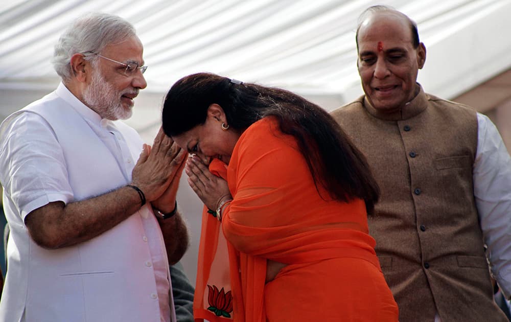 Vasundhara Raje greets party prime ministerial candidate and chief minister of Gujarat state Narendra Modi, left, and party president Rajnath Singh before her oath taking ceremony as the chief minister of Rajasthan in Jaipur.