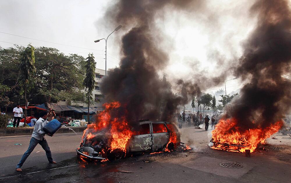 A Bangladeshi man tries to extinguish a car set afire by Islamist party Jamaat-e-Islami activists following the execution of their party leader Abdul Quader Mollah in Dhaka, Bangladesh.