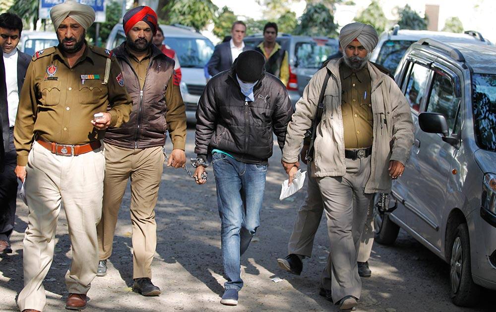 Indian national, Puneet, second right, accused of driving drunk in a hit-and-run car accident that killed an Australian student in Melbourne in 2008, is escorted by policemen after a hearing at a New Delhi court.