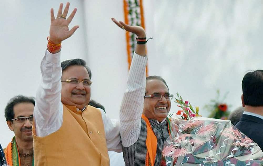 Chhattisgarh CM Raman Singh along with Madhya Pradesh CM Shivraj Singh Chouhan waves at the crowd during his swearing-in ceremony, in Raipur.