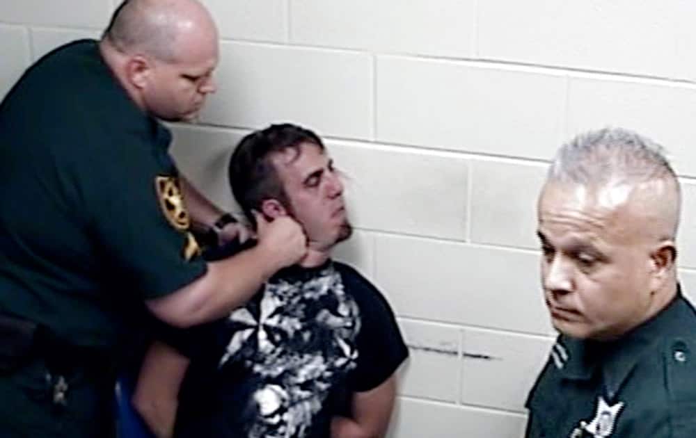 This image made from video provided by the Marion County Sheriff`s Office shows Marion County corrections officer Charlie Broaderick, left, slamming the head of James Duckworth while in custody.