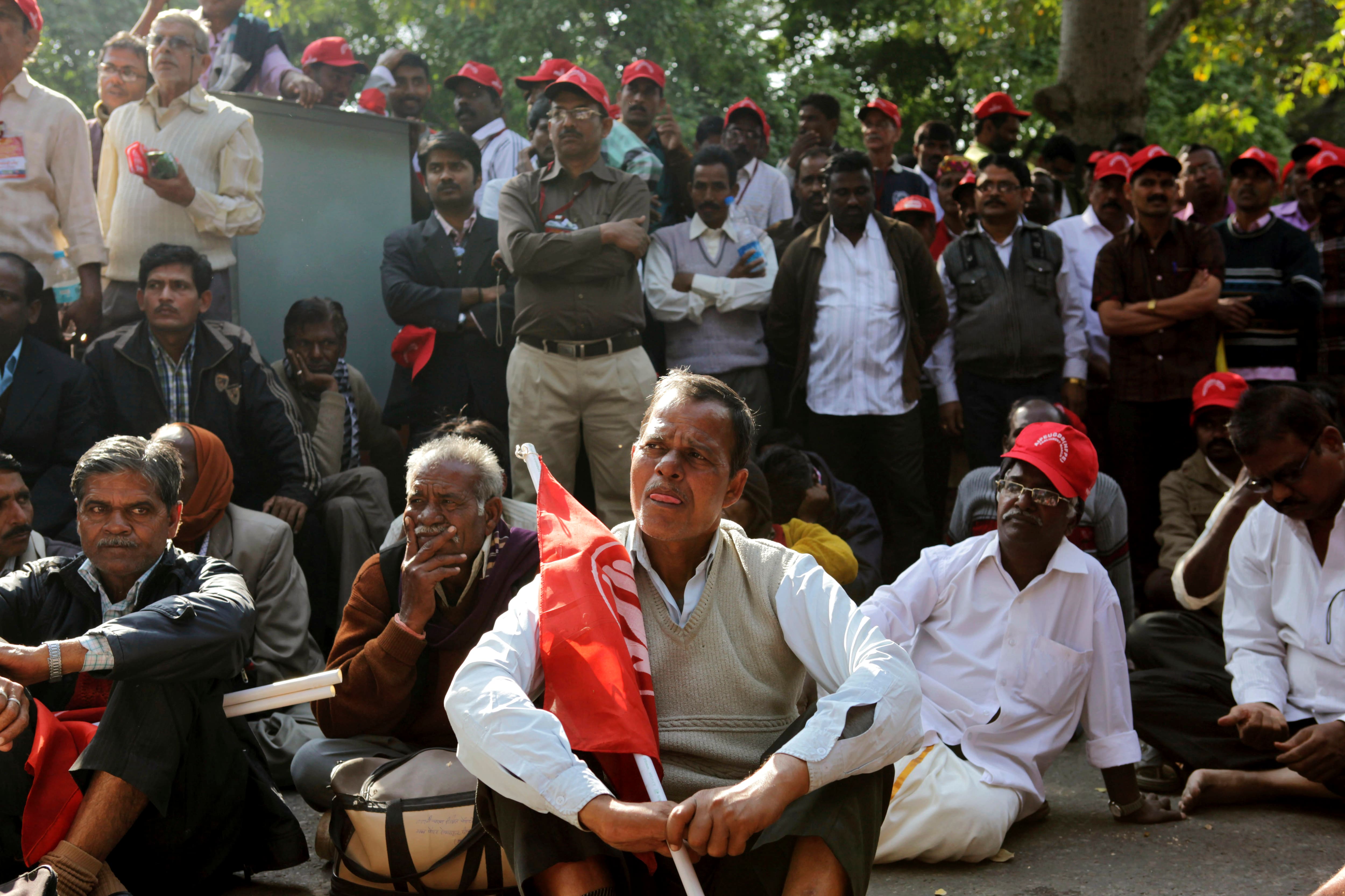 Indian postal department workers listen to a speaker as they protest near the Indian parliament demanding better service conditions in New Delhi.
