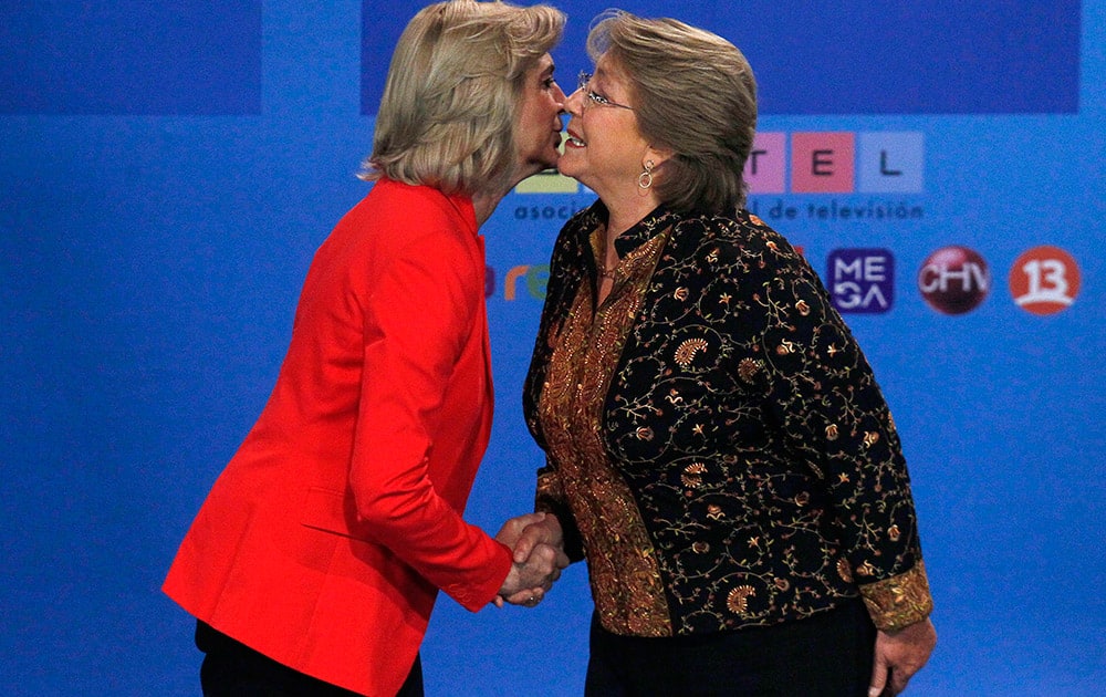 Chile`s presidential candidates, Michelle Bachelet, right, and Evelyn Matthei greet, obliging photographers` requests for a kiss before their television debate in Santiago, Chile.