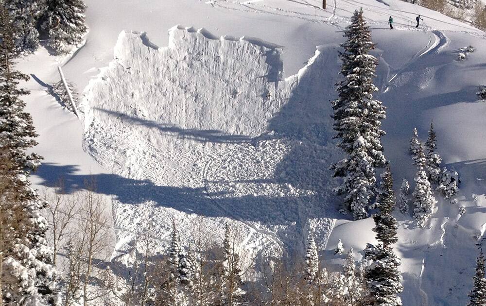 In this photo provided by Joseph Campanelli, the second in a sequence of three images, a skier is buried in an avalanche she triggered in a steep ravine in Grizzly Gulch, just outside the Alta ski area east of Salt Lake City.