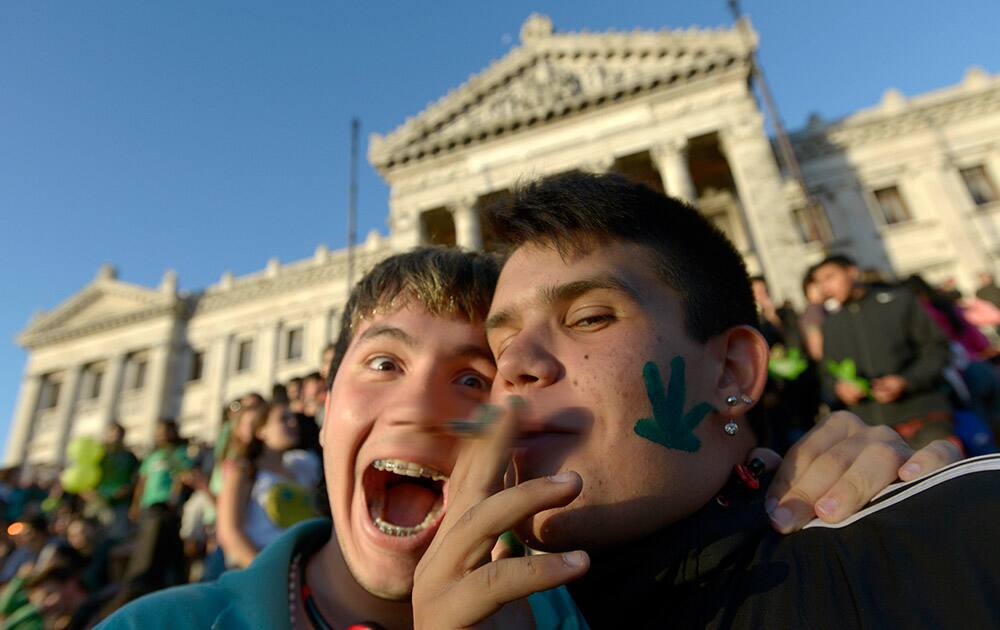An activist smokes a marijuana cigarette as they poses for photos in front of the Congress in Montevideo, Uruguay.