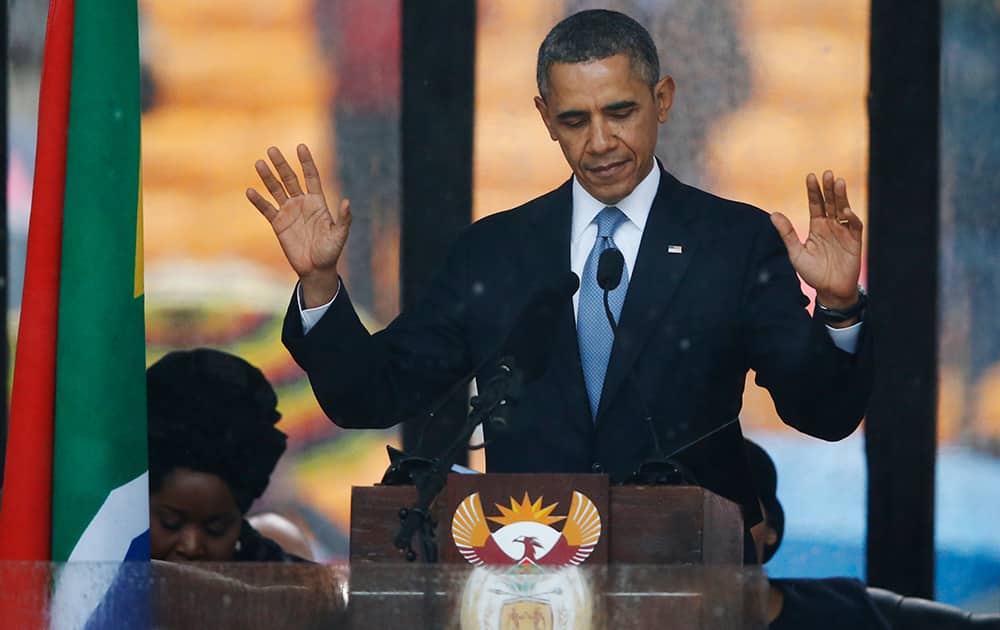 President Barack Obama acknowledges applause before speaking at the memorial service for former South African president Nelson Mandela at the FNB Stadium in Soweto near Johannesburg.