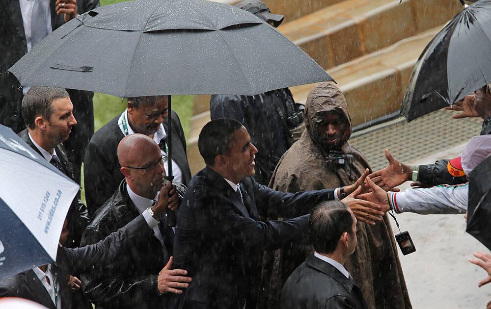 President Barrack Obama greets members of the crowd after making his speech during the memorial service for former South African president Nelson Mandela at the FNB Stadium in Soweto, near Johannesburg, South Africa.