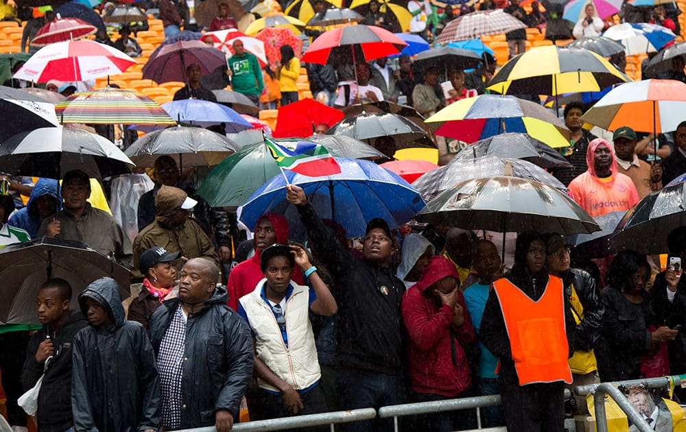 People watch as President Barack Obama speaks to crowds attending the memorial service for former South African president Nelson Mandela at the FNB Stadium in Soweto near Johannesburg.
