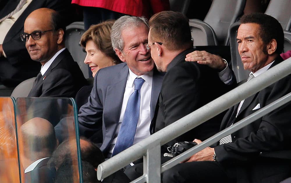 Former US President George W. Bush embraces Irish rock star Bono during the memorial service for former South African president Nelson Mandela at the FNB Stadium in Soweto, near Johannesburg, South Africa.