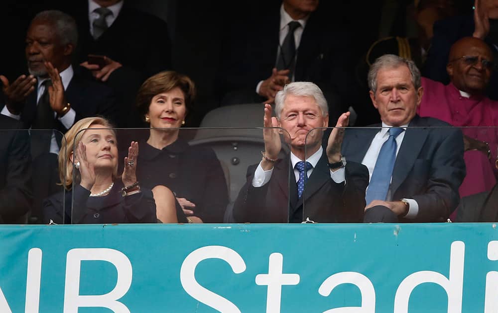 From left, Former US Secretary of State Hillary Rodham Clinton, Laura Bush, Former US President Bill Clinton and Former US President George W. Bush listen to speakers during the memorial service for former South African president Nelson Mandela at the FNB Stadium in Soweto near Johannesburg.
