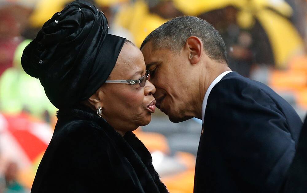 President Barrack Obama kisses Nelson Mandela`s widow Graca Machel during the memorial service for former South African president Nelson Mandela at the FNB Stadium in Soweto near Johannesburg.