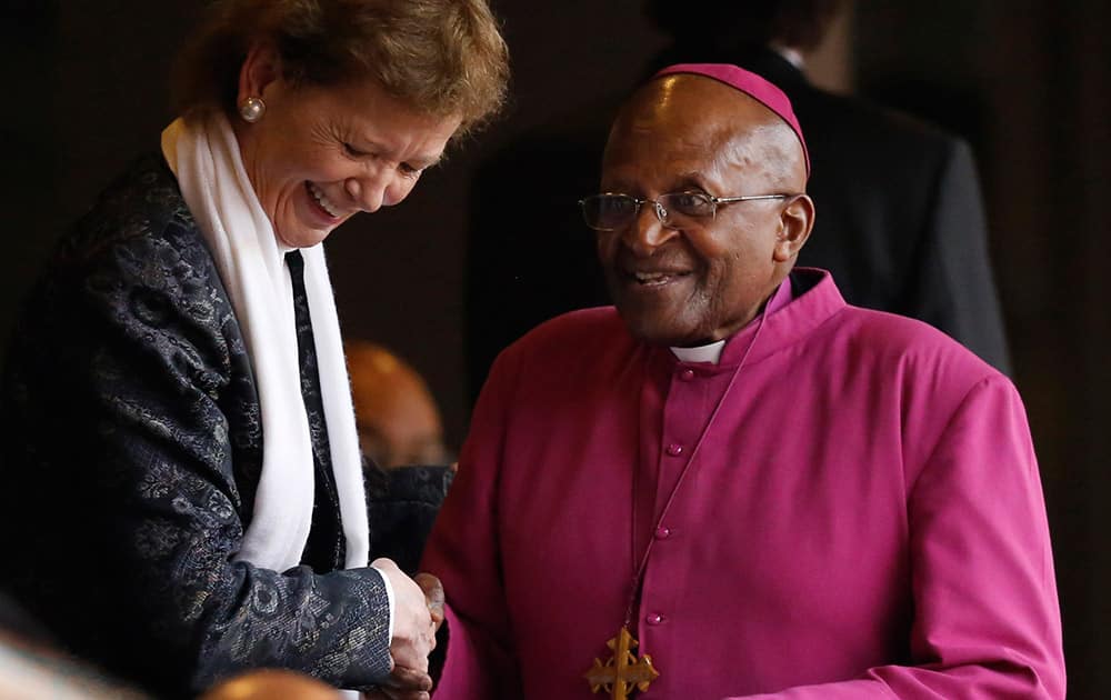Former Bishop Desmond Tutu, right, and Irish President Mary Robinson arrive for the memorial service for former South African president Nelson Mandela at the FNB Stadium in Soweto near Johannesburg.