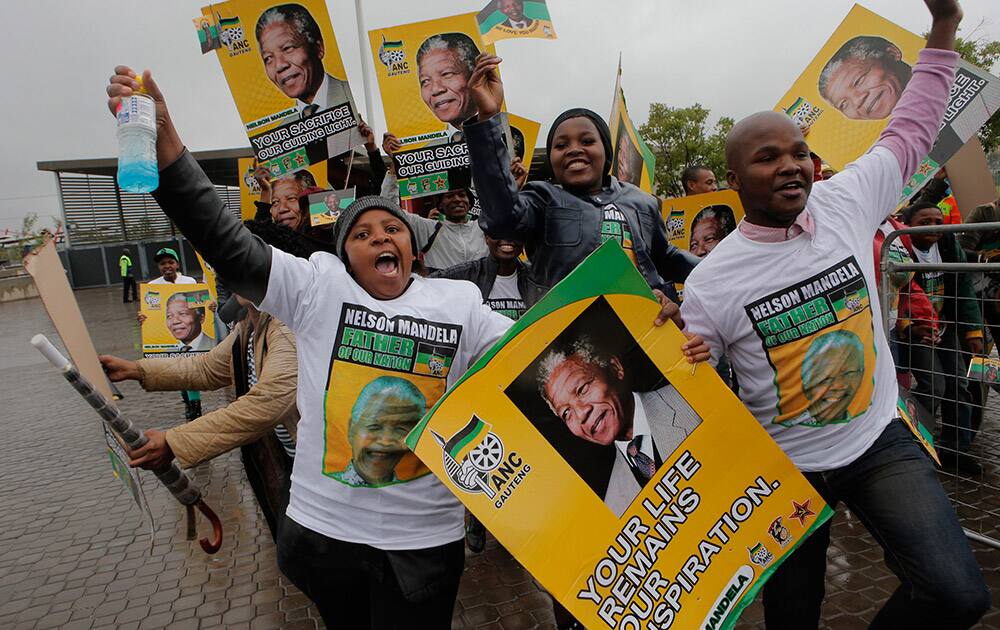 Former British Prime Minister Tony Blair, left, is greeted after arriving for the memorial service for former South African president Nelson Mandela at the FNB Stadium in Soweto near Johannesburg.
