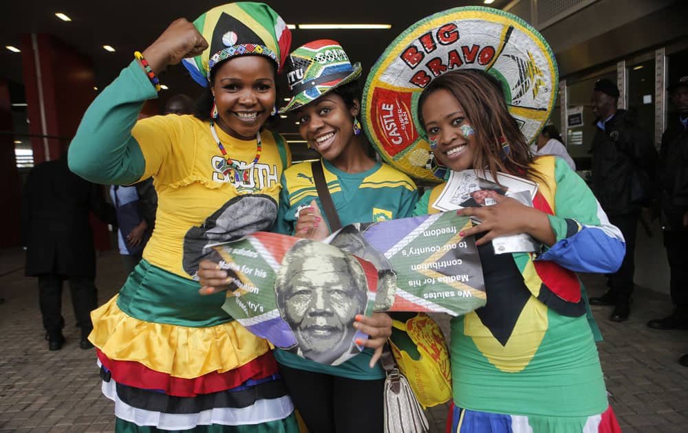 Women pose for a photo as they arrive for the memorial service for former South African president Nelson Mandela at the FNB Stadium in Soweto, near Johannesburg, South Africa.
