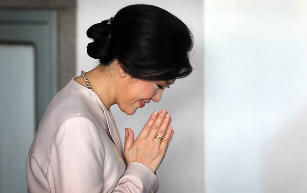 Thailand Prime Minister Yingluck Shinawatra greets her colleagues as she arrives at a Cabinet meeting, in Bangkok, Thailand.